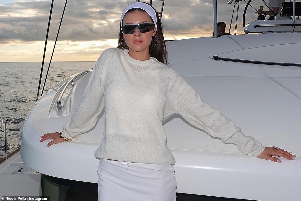 Fashion moment: The Bates Motel actress stylishly posed wearing a white skit and sweater as she posed for a photo with the sun setting behind her