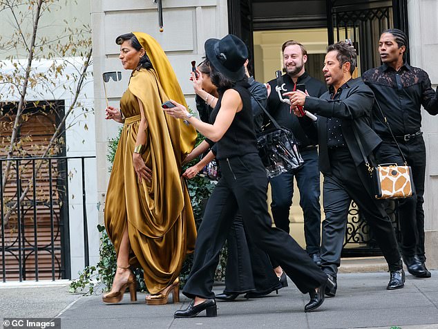 Entourage: The star was surrounded by scores of people taking photos