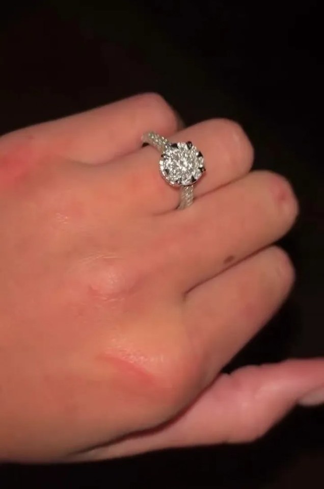 Hand displaying a dazzling engagement ring.