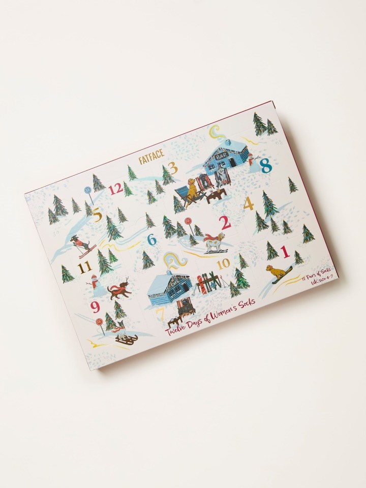 Illustration of a Fatface advent calendar with a snowy winter scene of dogs skiing and sledding, with ski lodges and trees.