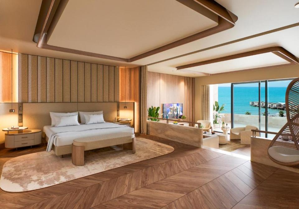 Luxury hotel room at Regnum The Crown, Turkey, with a large bed, living area, and balcony overlooking the sea.