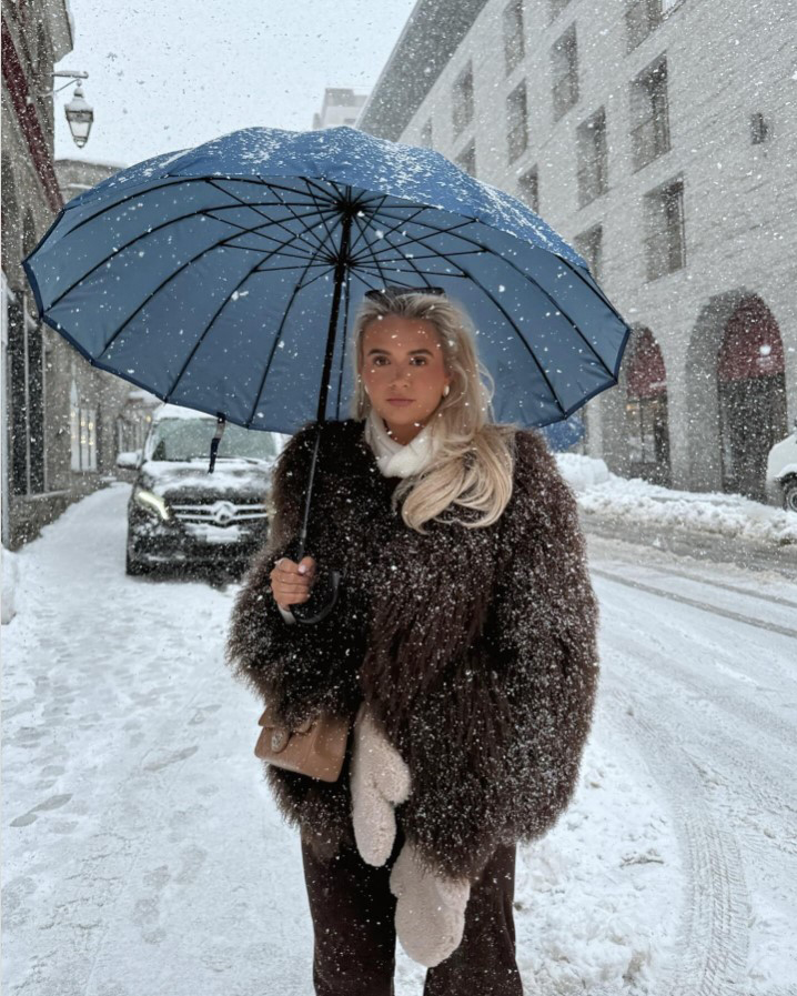 Molly-Mae Hague in a snowsuit holding a blue umbrella in St. Moritz.
