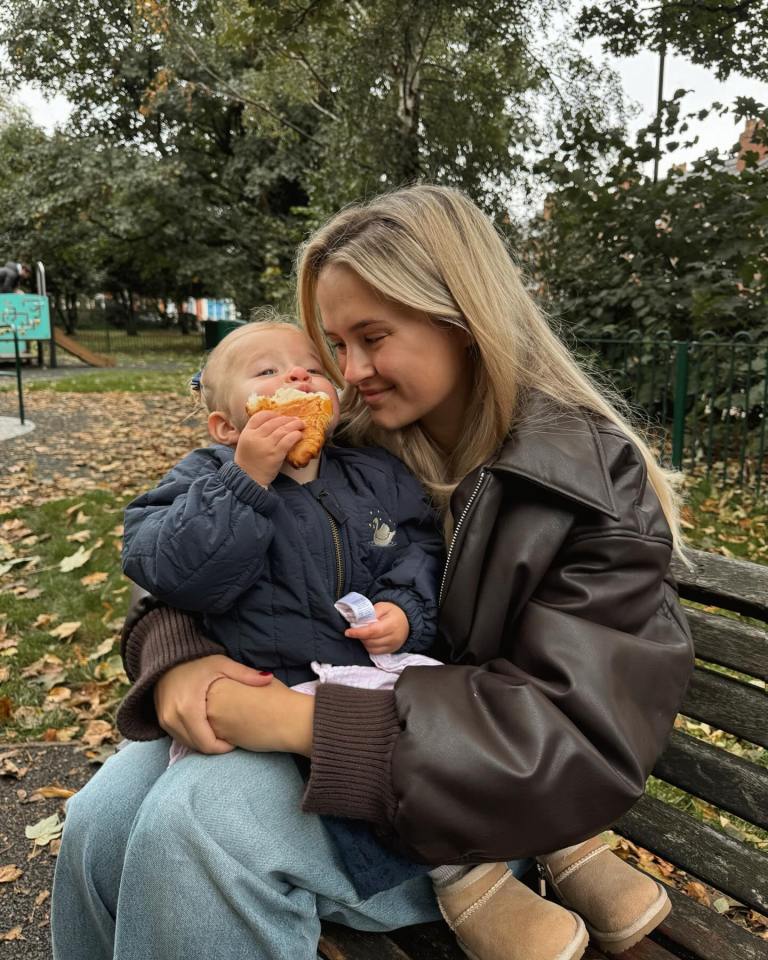 Molly-Mae Hague holding Bambi, who is eating a croissant.