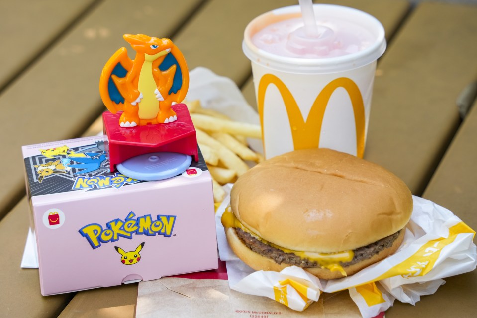 McDonald's Happy Meal set with a Mega Charizard Y Pokémon toy, hamburger, fries, and drink.