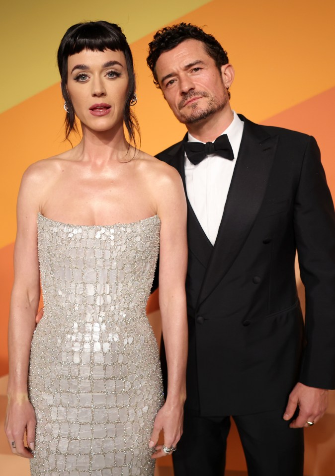 Katy Perry in a strapless silver gown and Orlando Bloom in a black tuxedo.