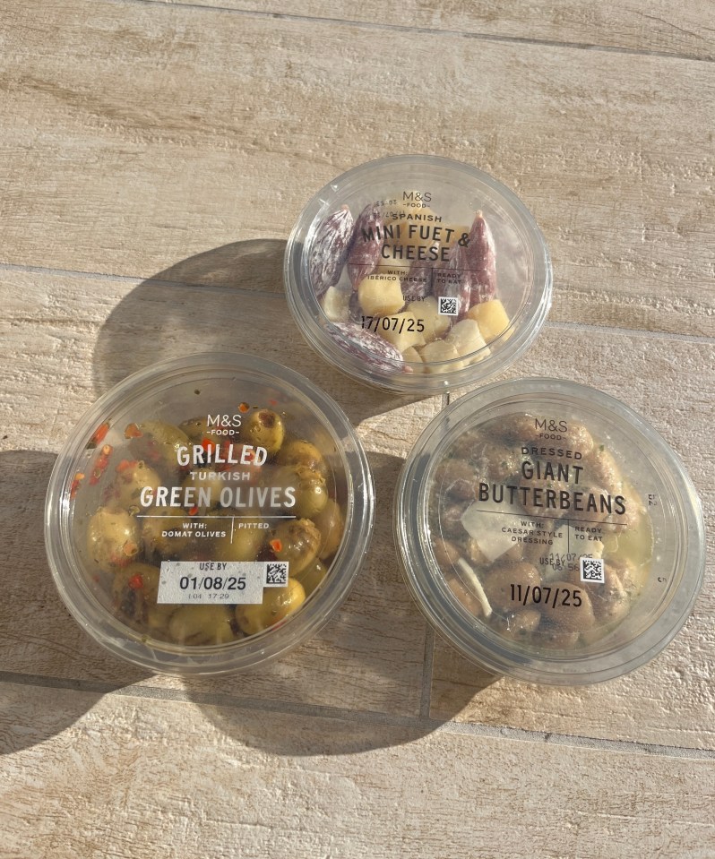 Three containers of M&S dips: mini fuet & cheese, grilled Turkish green olives, and dressed giant butterbeans.