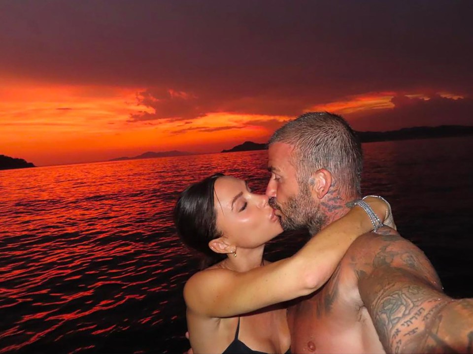 Victoria and David Beckham kissing on a boat at sunset.