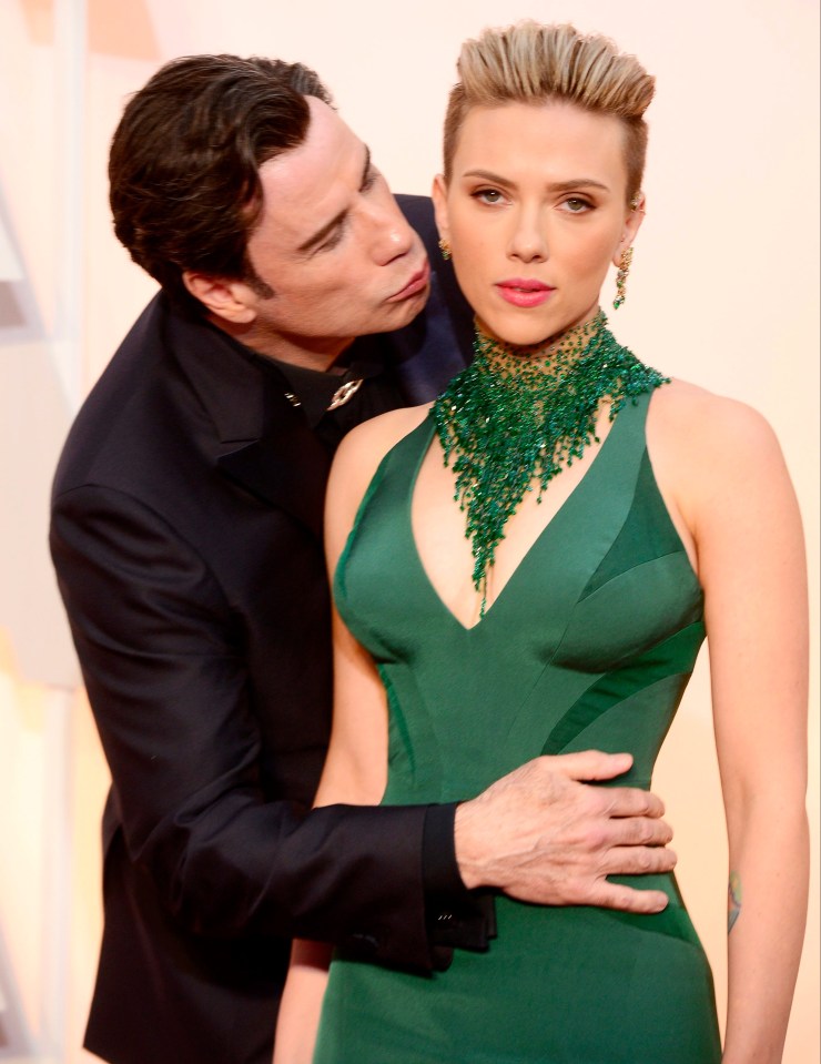John Travolta kisses Scarlett Johansson as they arrive for the 87th annual Academy Awards ceremony.