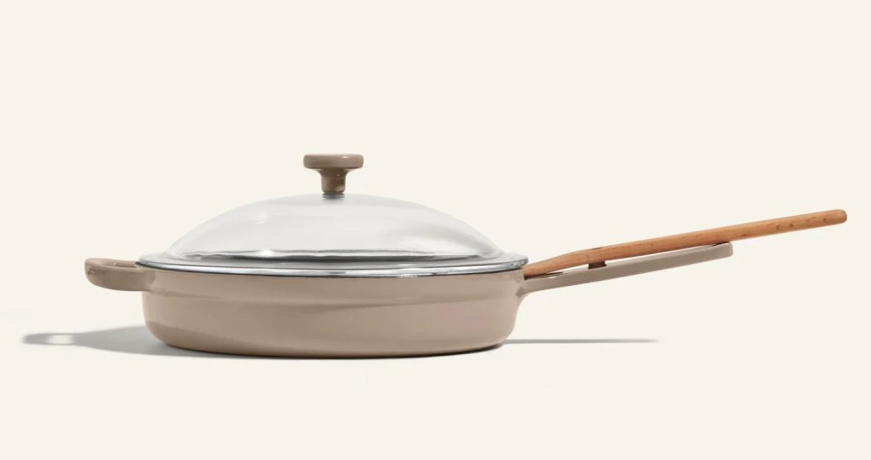 Light brown cooking pan with a clear lid and a wooden handle.