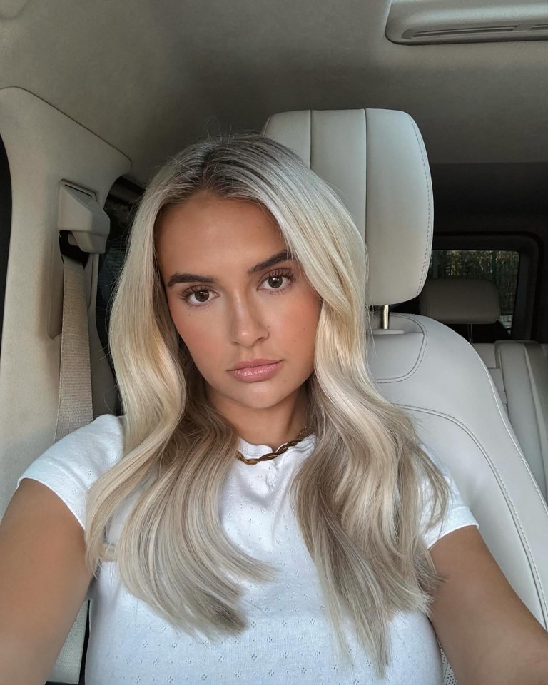 Woman with long blonde hair in a car.