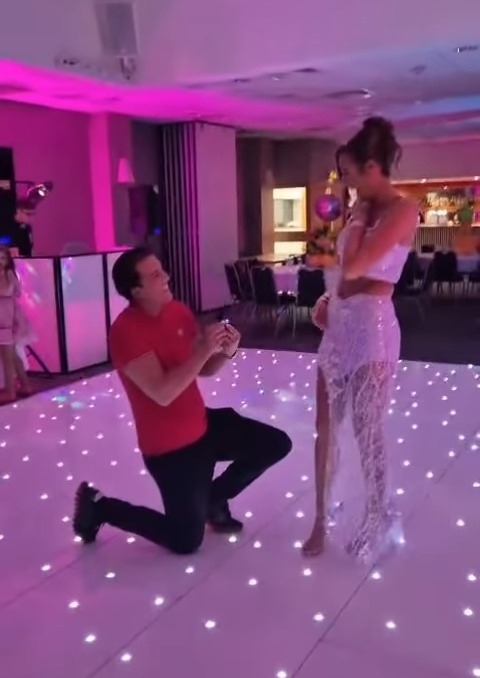 A man proposing to a woman at an event.