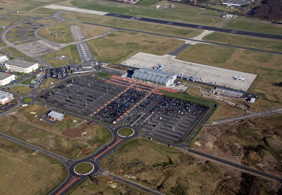 Aerial view of Doncaster Sheffield Airport with terminal, runways, and parking lots.