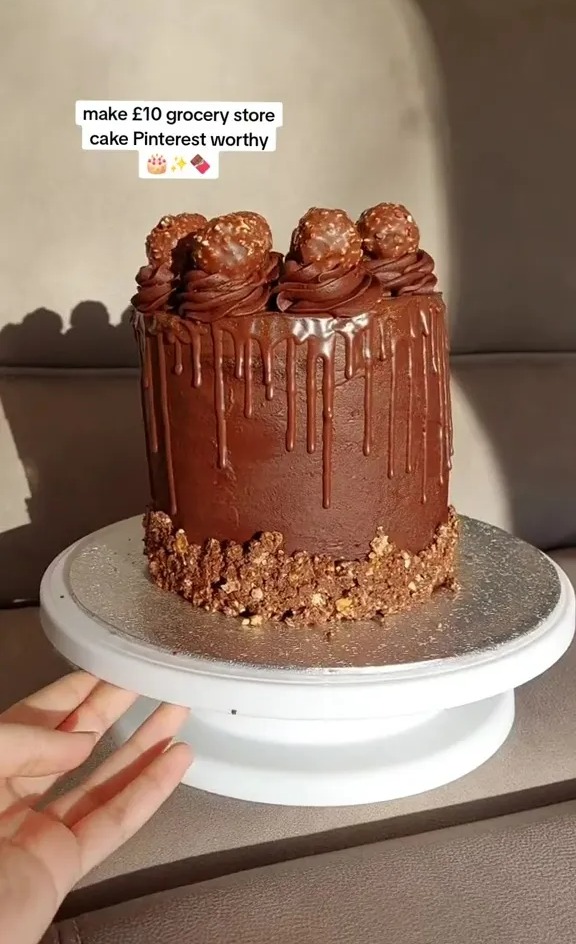 Chocolate cake decorated with chocolate balls and a chocolate drip.