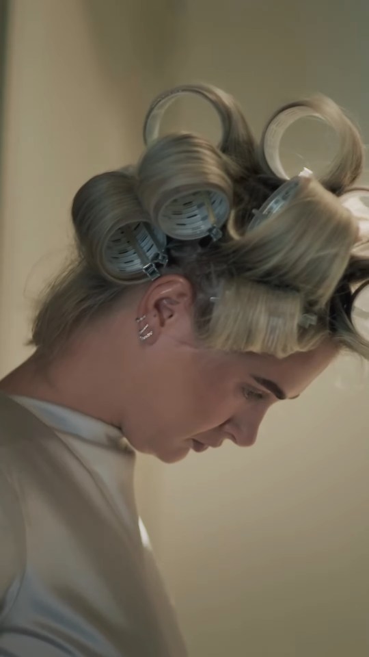 Molly-Mae Hague with hair rollers, looking down.