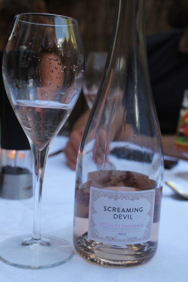 A glass of rosé and a bottle of Screaming Devil rosé.