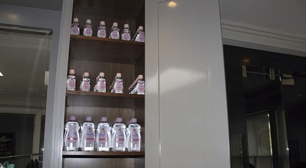 Shelves in Sean Diddy Combs' home filled with baby oil bottles.