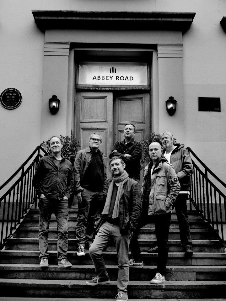 A black and white photo of the Divine Comedy SFTW music band at Abbey Road.
