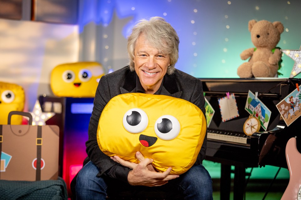 Jon Bon Jovi holding a yellow soft toy for Cbeebies Bedtime Story.