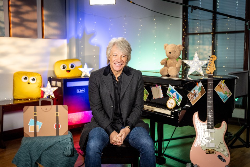 Jon Bon Jovi sitting in front of a piano and guitar.