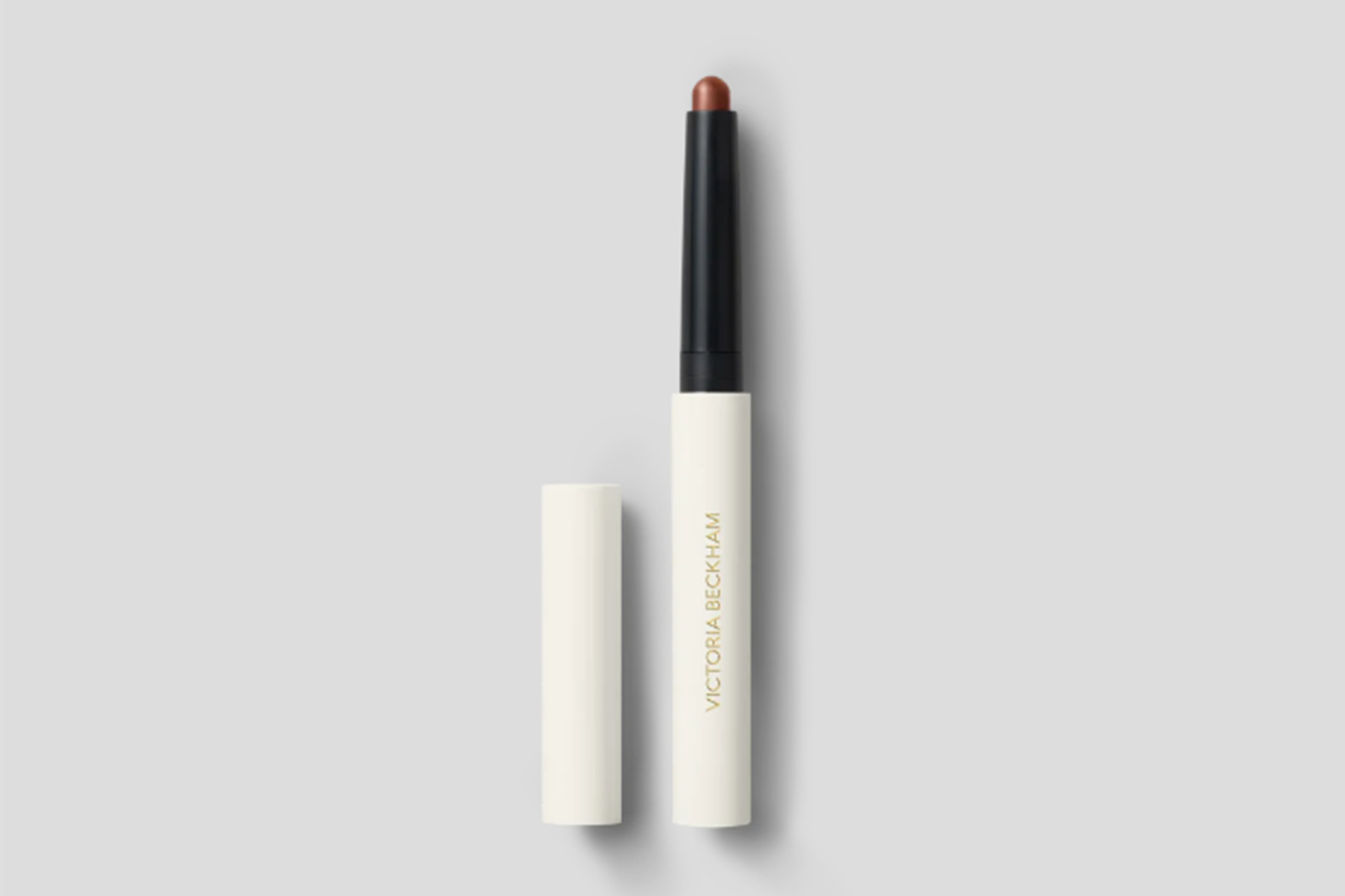 Victoria Beckham Beauty Contour Stylus in a light brown shade with its white cap removed.