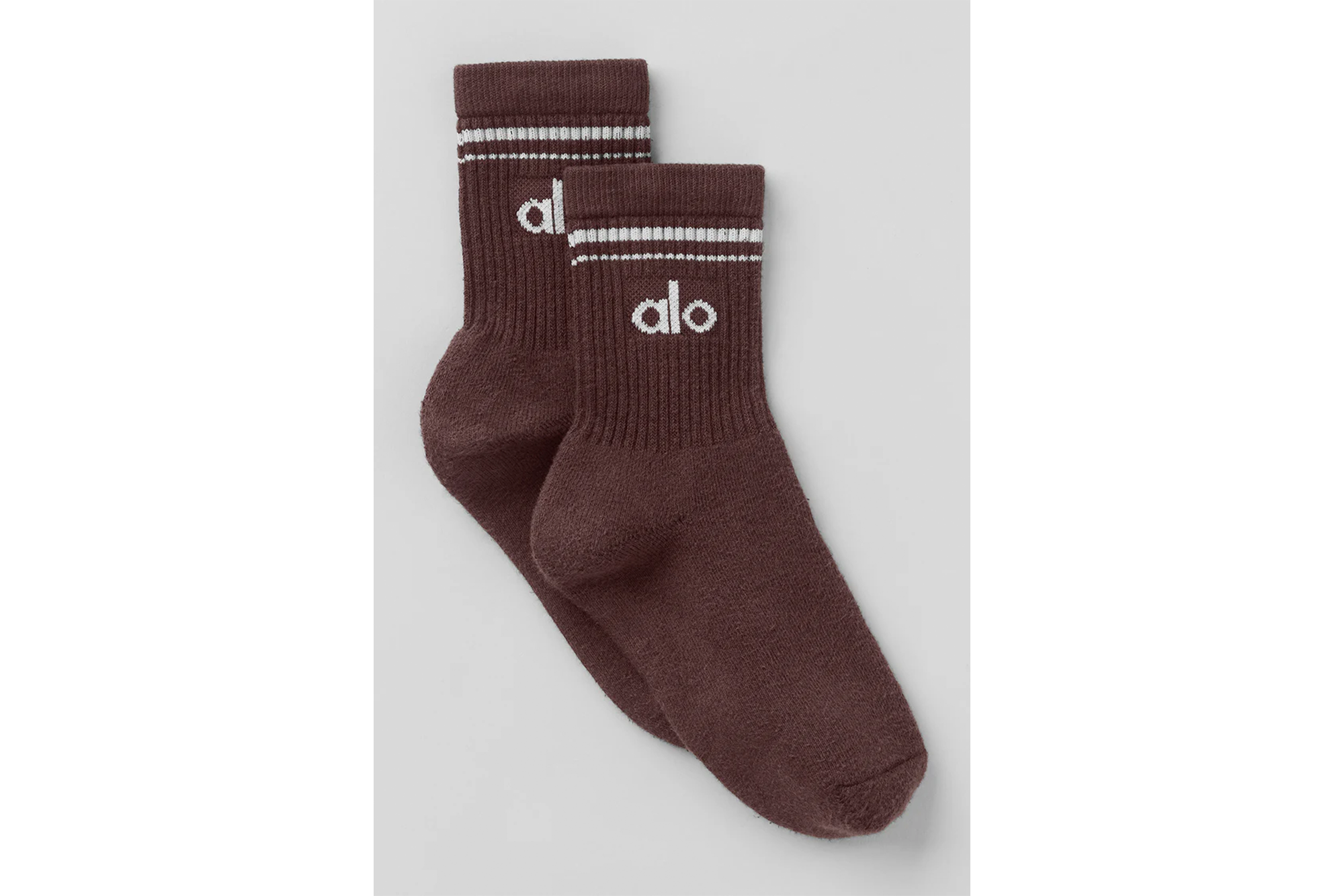 Two brown socks with white stripes and "alo" branding.