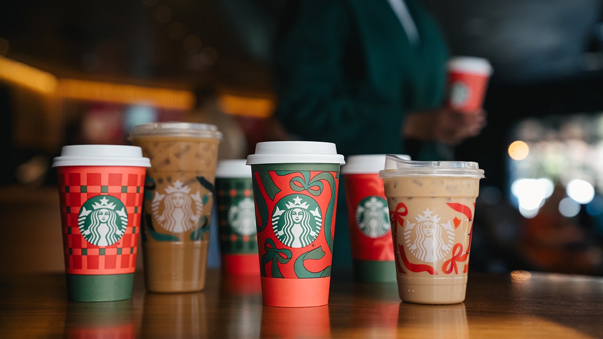 Starbucks holiday drinks and cups on a table at a cafe