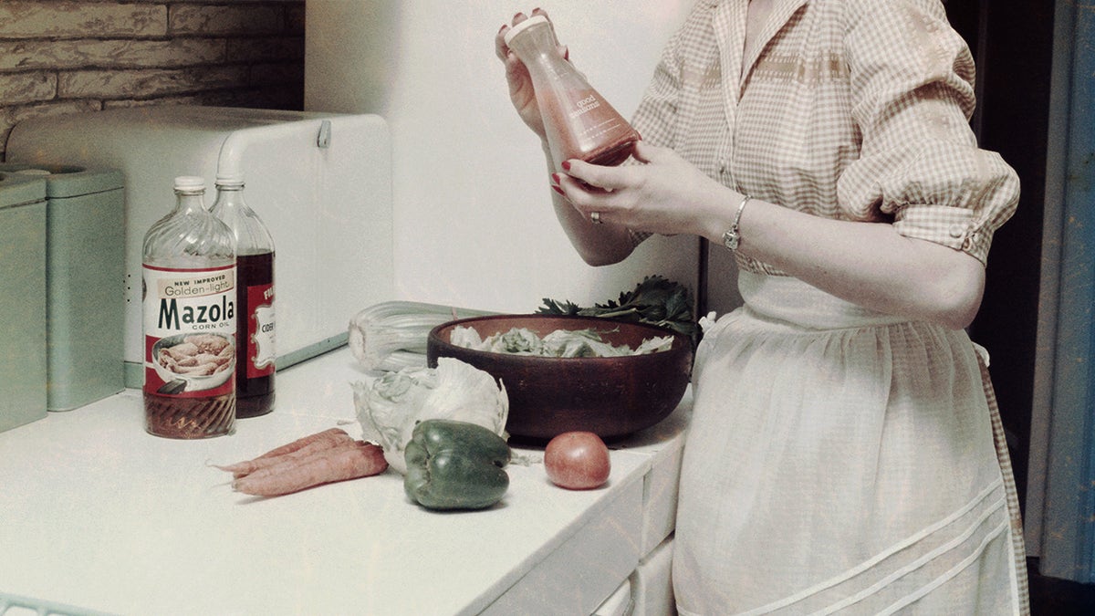 A housewife in the 1950s preparing a salad in kitchen